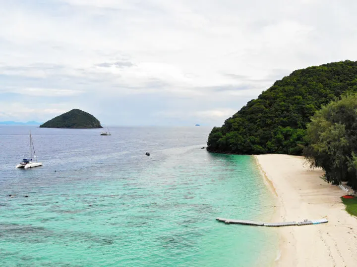 coral island thailand view of kahung beach from above teal water white sand lush coast