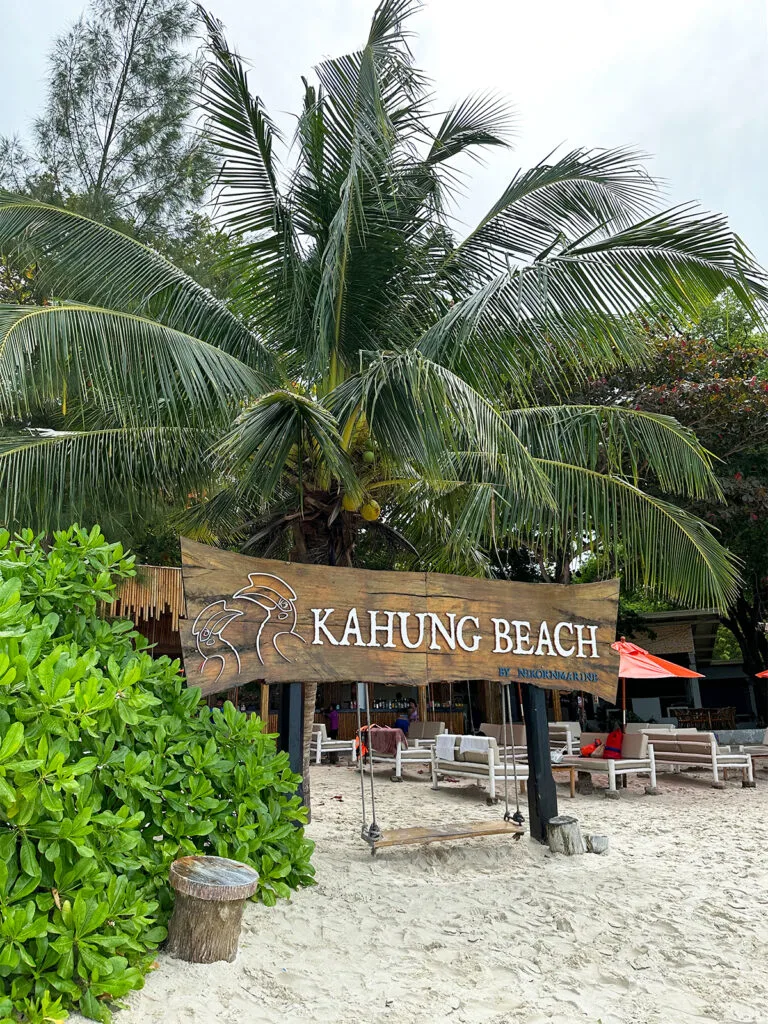 kahung beach sign in thailand white beach palm tree wooden swing