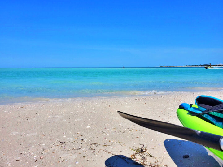 kayak near ocean teal color and blue sky