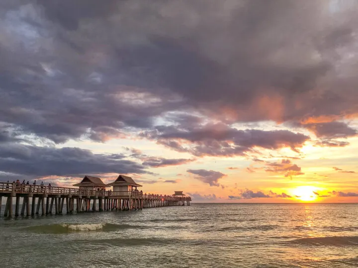 pier at sunset with moody sky and ocean view of one of the best beaches on the gulf coast