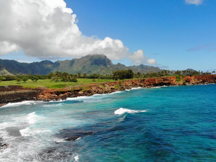 kauai vs. maui hiking trail with blue ocean red coast white clouds mountains