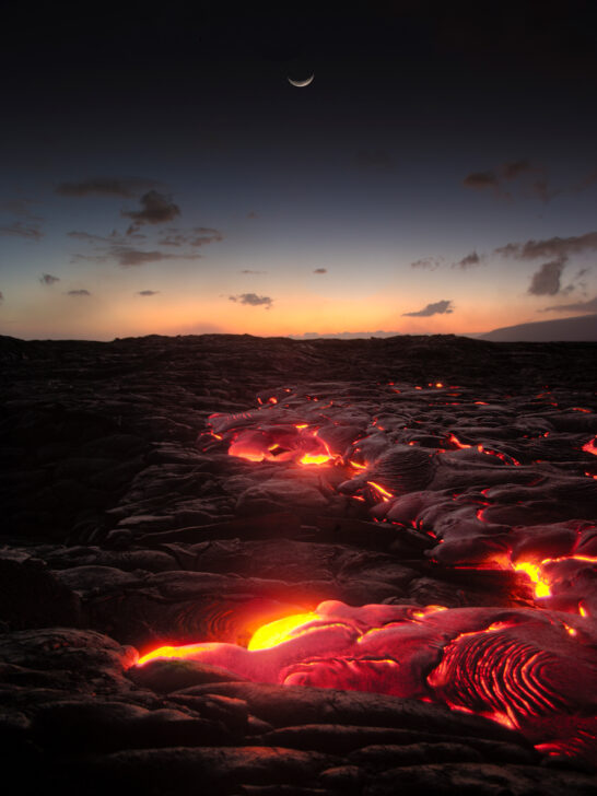 packing for hawaii volcanoes national park red lava at night with sun setting low in sky