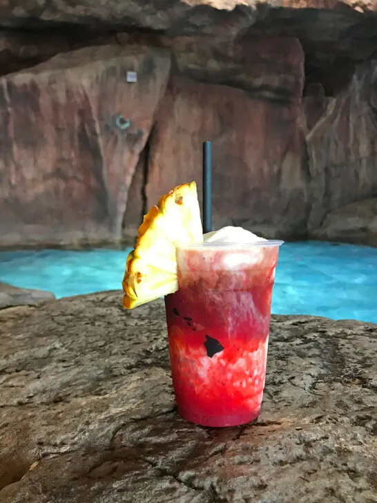 fruity drink with straw and pineapple in pool cave