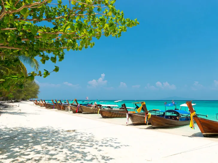 long tail boats and white sand beach on bamboo island phi phi islands