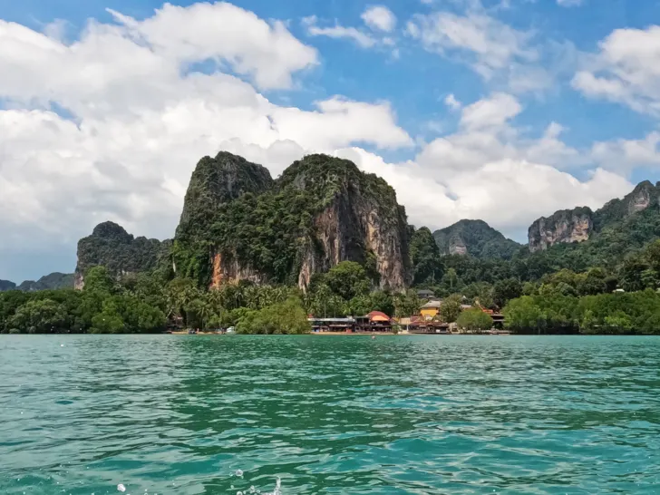 Krabi to Koh Phi Phi view of Andaman sea with green and tan hillside on sunny day