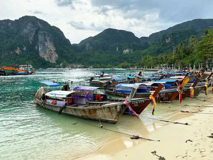 Koh Phi Phi view of beach with long tail boats on shore and hillside in distance