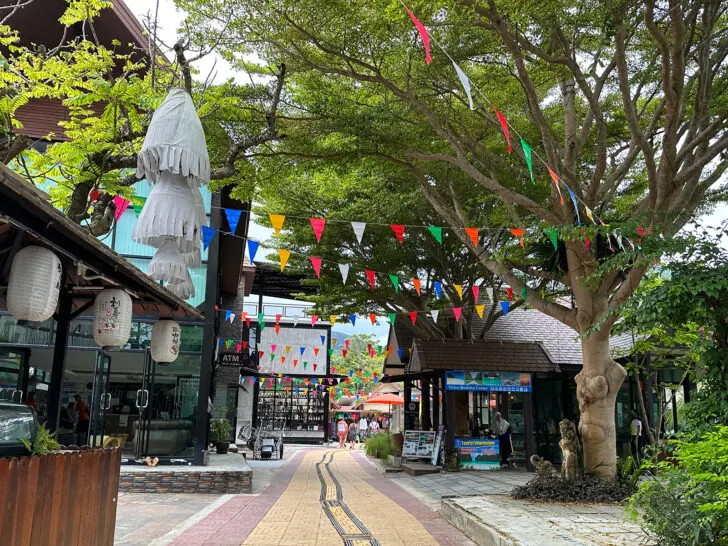 brick street with flags and trees and restaurants nearby shopping village