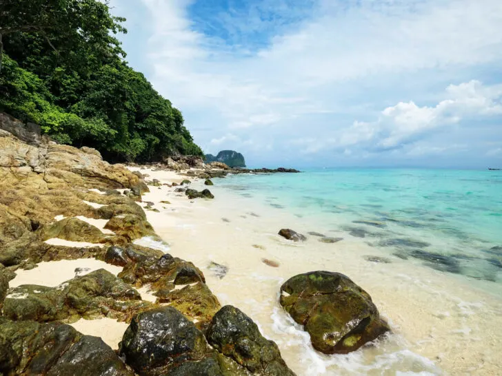 beautiful beaches in Thailand view of white sand rocky beach with teal water on cloudy day