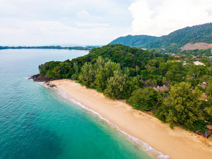 most beautiful beaches in thailand aerial view of Long Beach with tan sand trees and teal water with land in distance