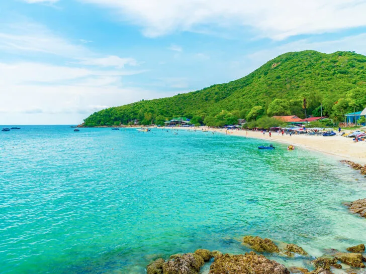 best thailand beaches teal water rocky shore with sand and green hillside on coast