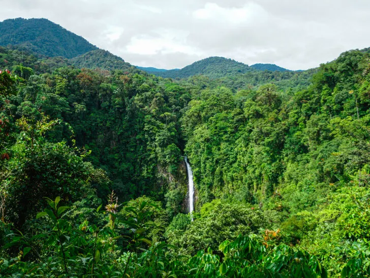 La Fortuna waterfall Costa Rica 1 week itinerary view of waterfall in lush rainforest from a distance