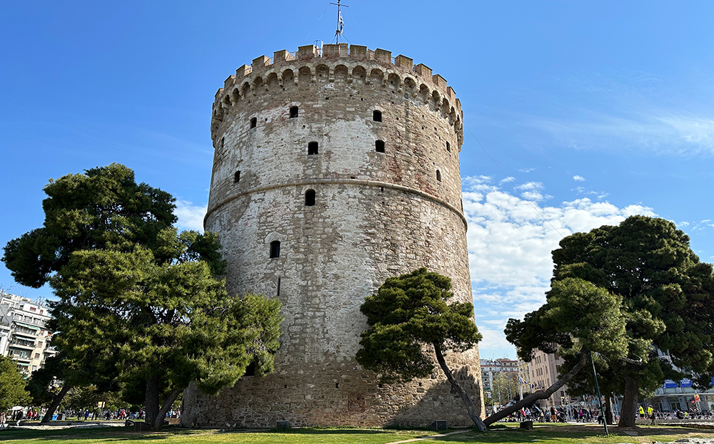 Macedonia Greece travel guides view of White Tower in Thessaloniki with trees and round stone structure