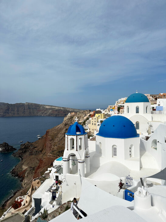 white buildings with blue accents on hilltop in Santorini