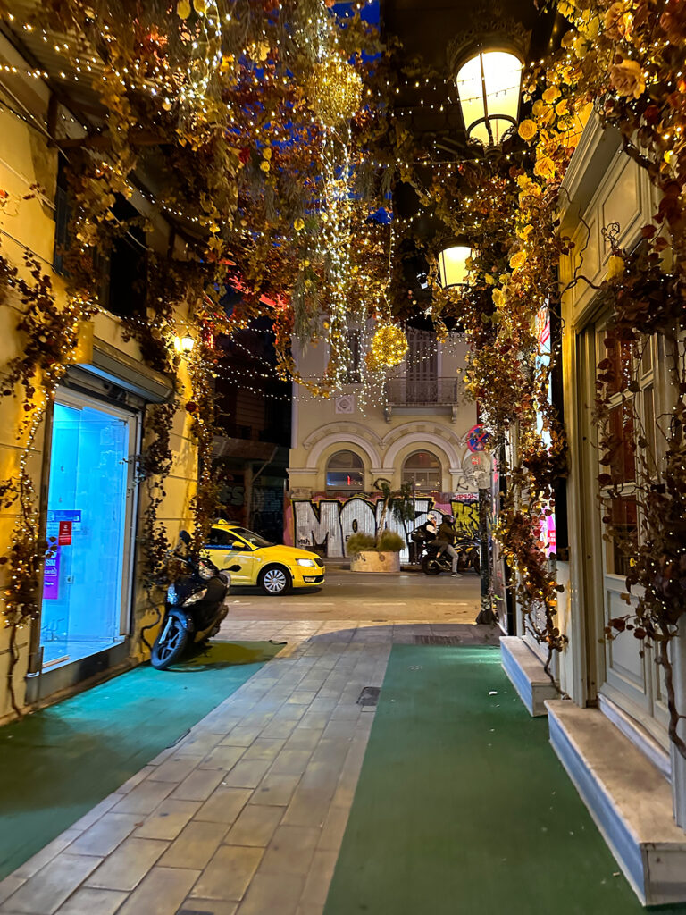 Aegean Sea Cruise stop in Athens at night with flowers and lights in alleyway