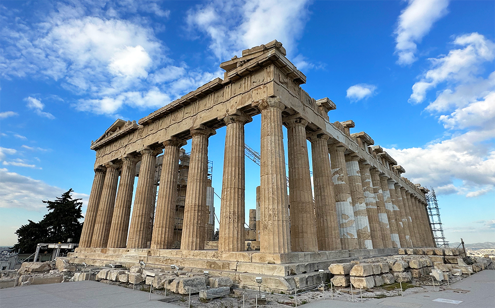 Central Greece travel guide view of Parthenon in Athens Greece with large stone pillars ancient structure with blue sky