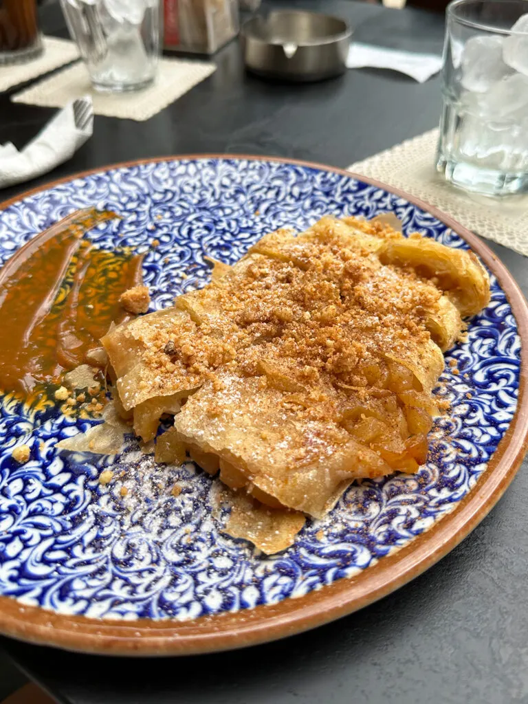 cruising the greek islands enjoying bougatsa in Crete cinnamon pastry with apples on blue plate in Heraklion Crete