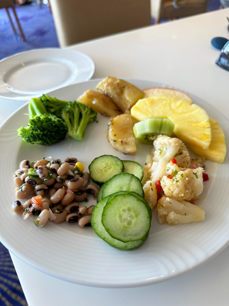 plate full of fruit veggies and black eyed peas