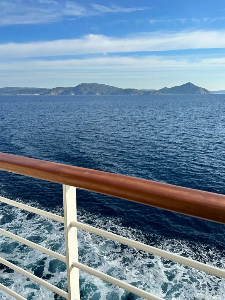 railing and ocean with land in distance