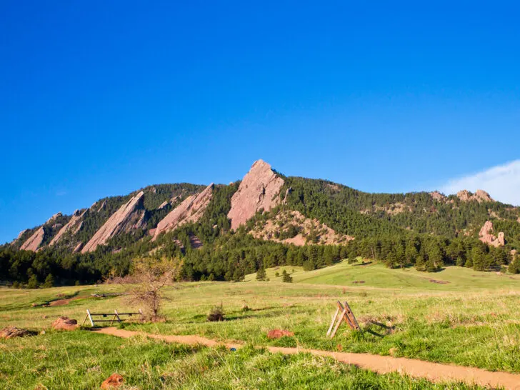 road trip colorado with rock slab mountains with trees and field in foreground