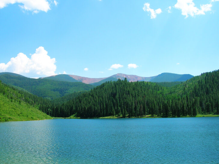 colorado road trip with blue lake green trees and mountains
