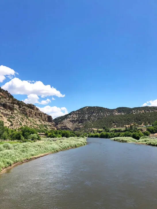 colorado road trip view of river through canyon on sunny day