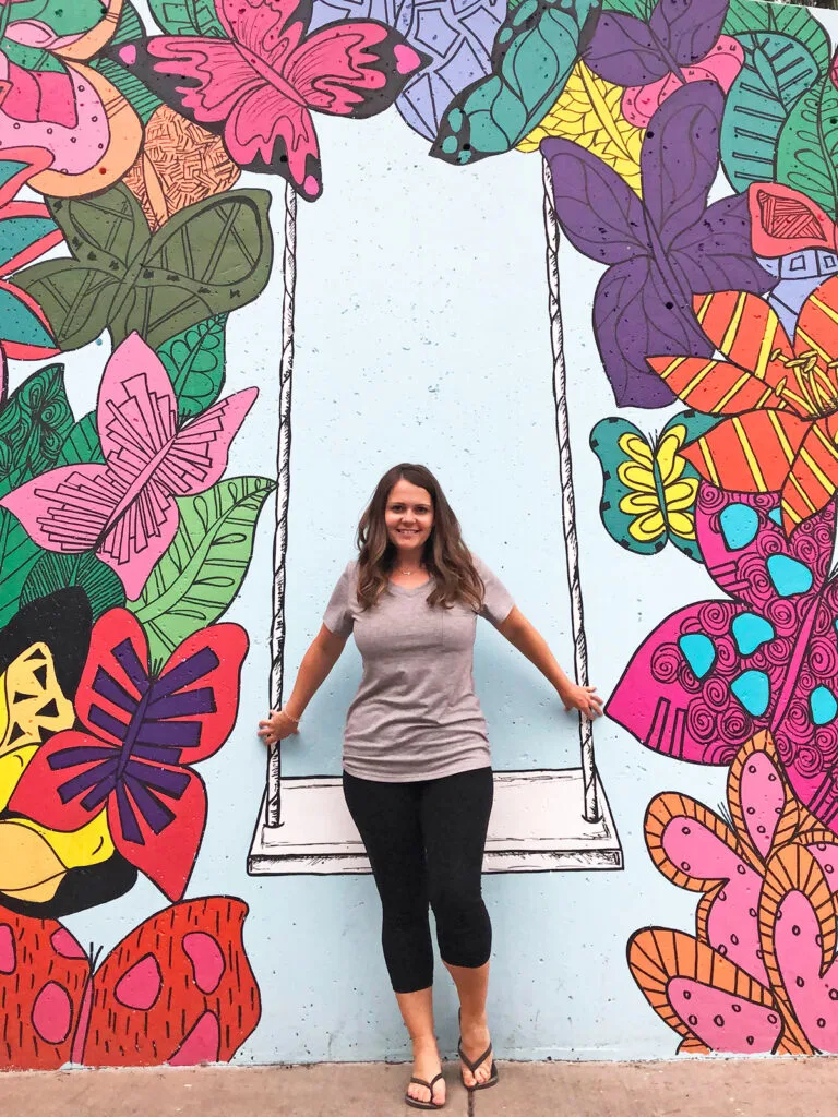 plan a trip to Colorado with woman standing in front of colorful butterfly mural