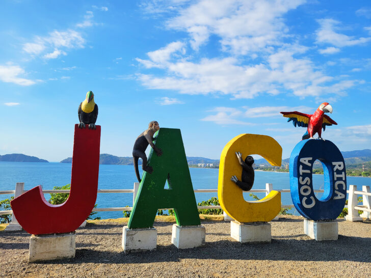 Jaco sign with multi colors and ocean in distance