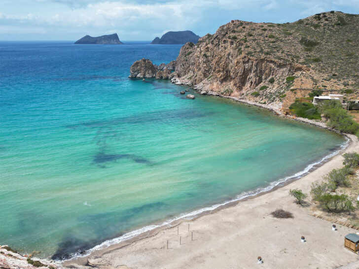 Milos Greece view of beach teal water and hill coast
