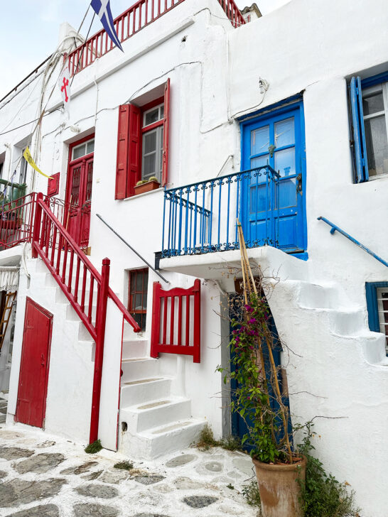 view of red and blue accents on white buildings while touring Mykonos greece