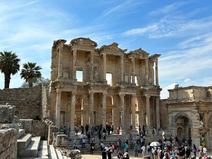 large stone structure with columns and people below in Ephesus Turkey while cruising Aegean Sea