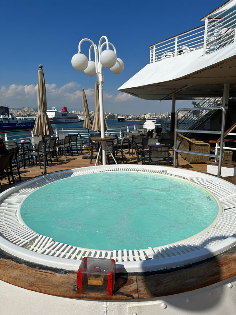 best cruise greek islands celestyal cruises view of ship deck with hot tub and Athens port in distance