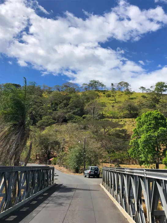 7 days in Costa Rica view of road over bridge with hill in distance