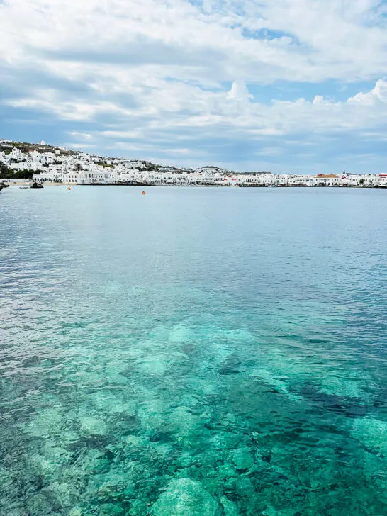 Santorini and mykonos view of bright water and white buildings in distance at port