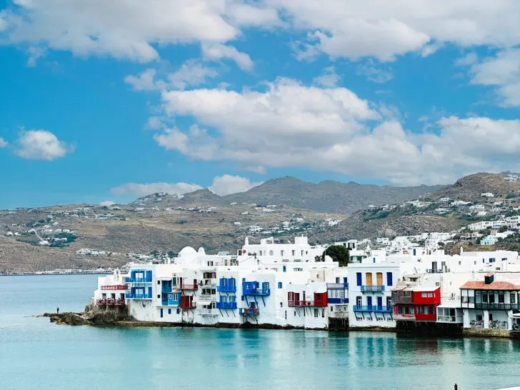 view of white houses along sea with brightly colored red and blue accents