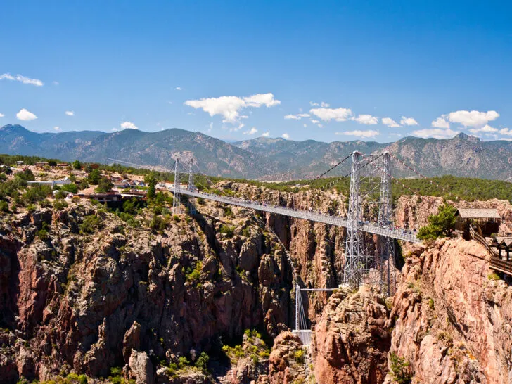 colorado road trip in Canon City CO with suspension bridge and mountains in distance