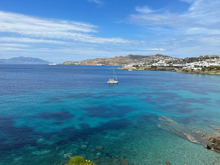 stunning blue water near the coast of Mykonos with one catamaran