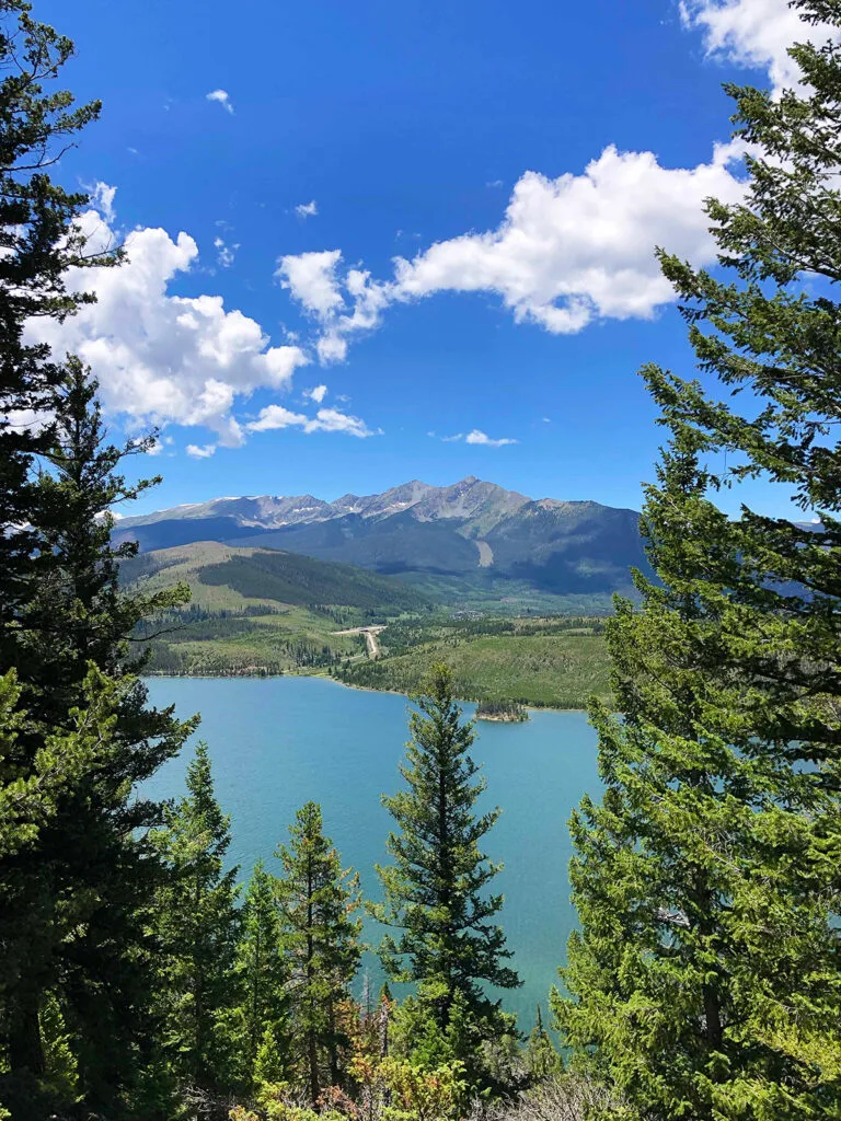 colorado road trip itinerary view of bright blue lake and mountains with trees