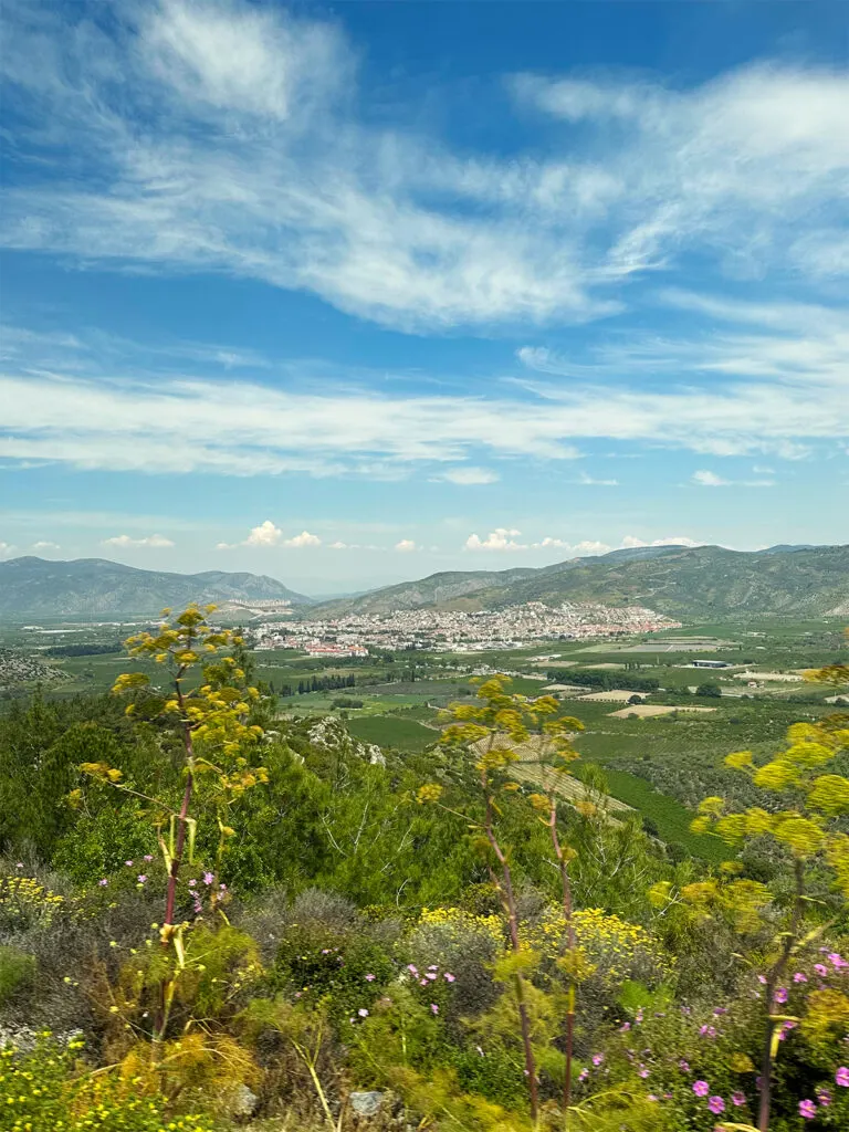 sailing Aegean Sea view of Turkey hillside with farmland and city in mountains