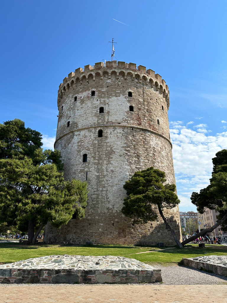 sailing Aegean Sea view of white tower at Thessaloniki port large stone round tower with trees