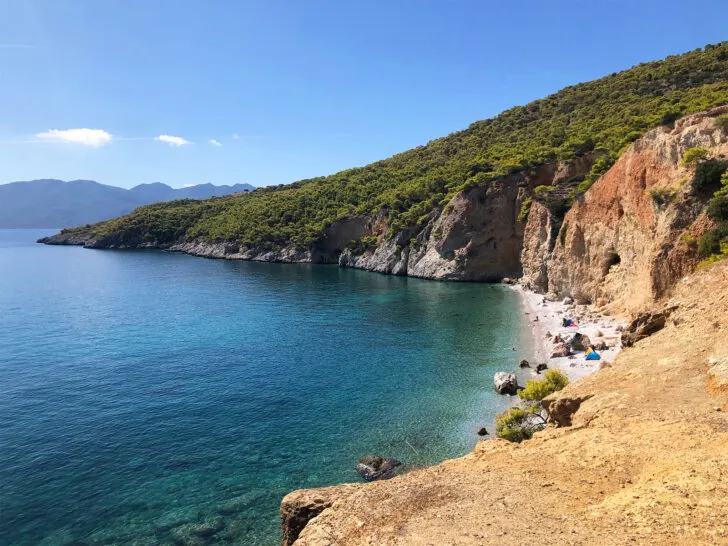 best Greek islands to visit view of shoreline with hillside beach and blue water