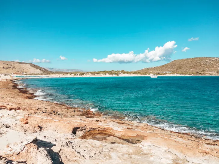 rocky cliffside leading to green blue water one of the best place in greece for couples