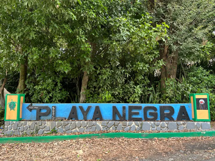 large sign that reads playa negra with trees behind it