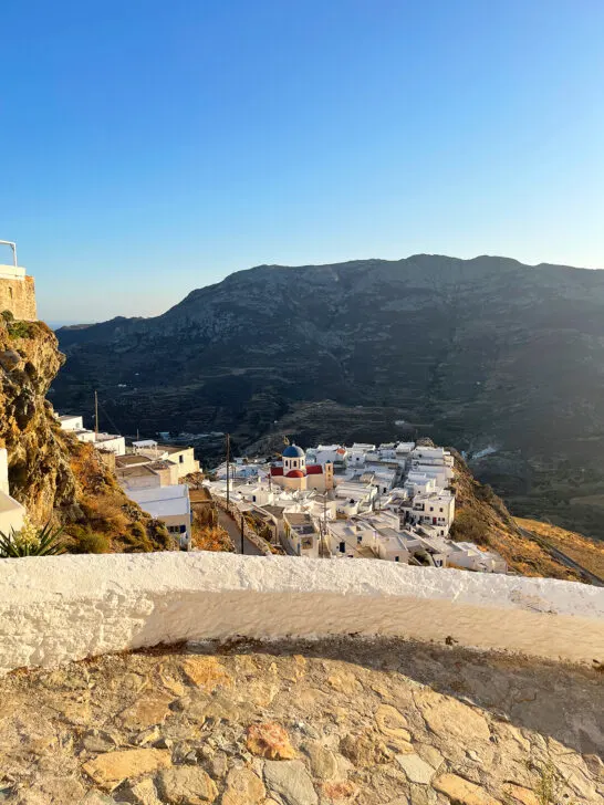 town below walkway at dusk with hillside in distance best island in greece for couples to visit