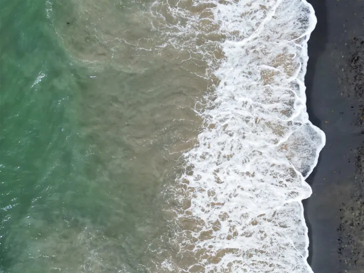 perfect view of black sand beach vieques teal water white wave black sand from above