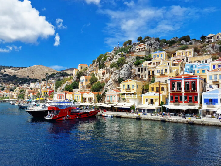 colorful town along sea with many buildings and boats best greek islands to visit at Symi