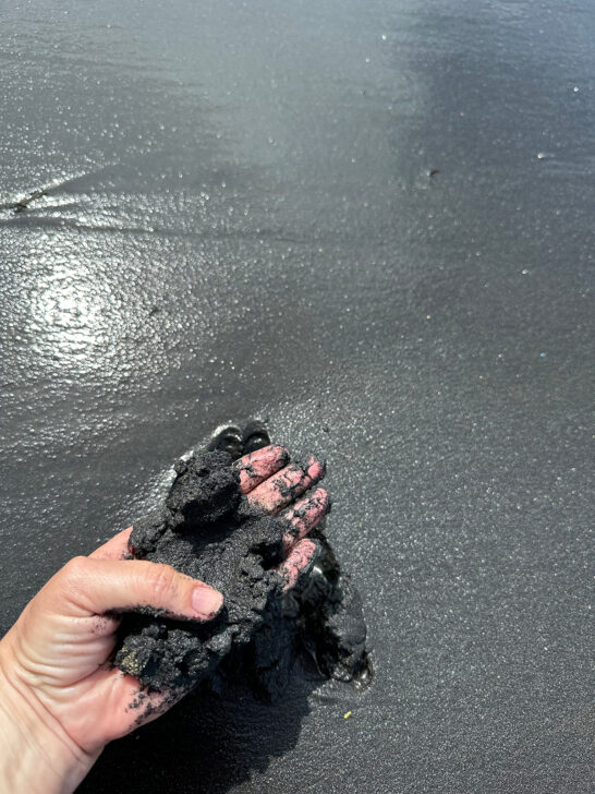 hand grabbing fine black sand at playa negra Puerto Rico