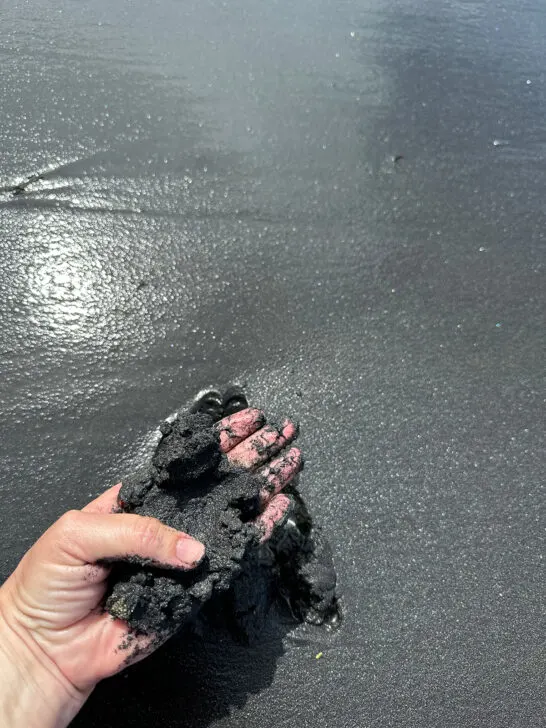 hand grabbing fine black sand at playa negra Puerto Rico