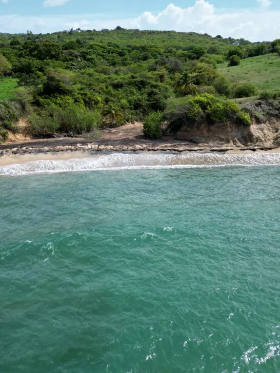 best beach in Vieques view of blue water white waves sand and green island