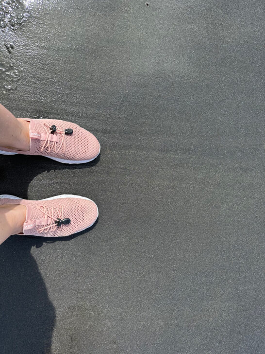pink water shoes on black sand beach vieques