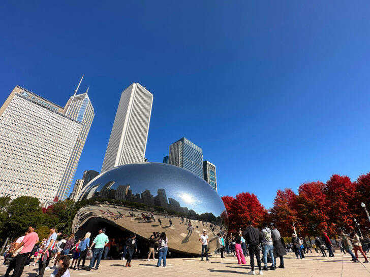 chicago bean large reflective art installation with city skyline people and red trees in autumn